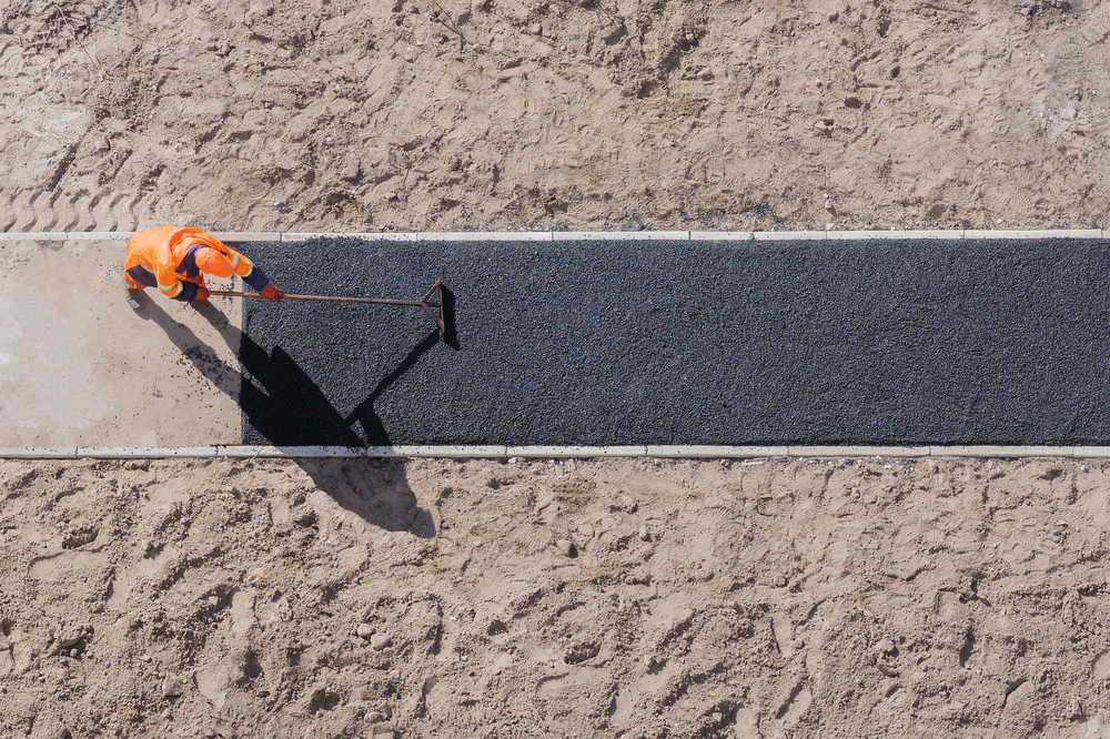 a worker laying new asphalt